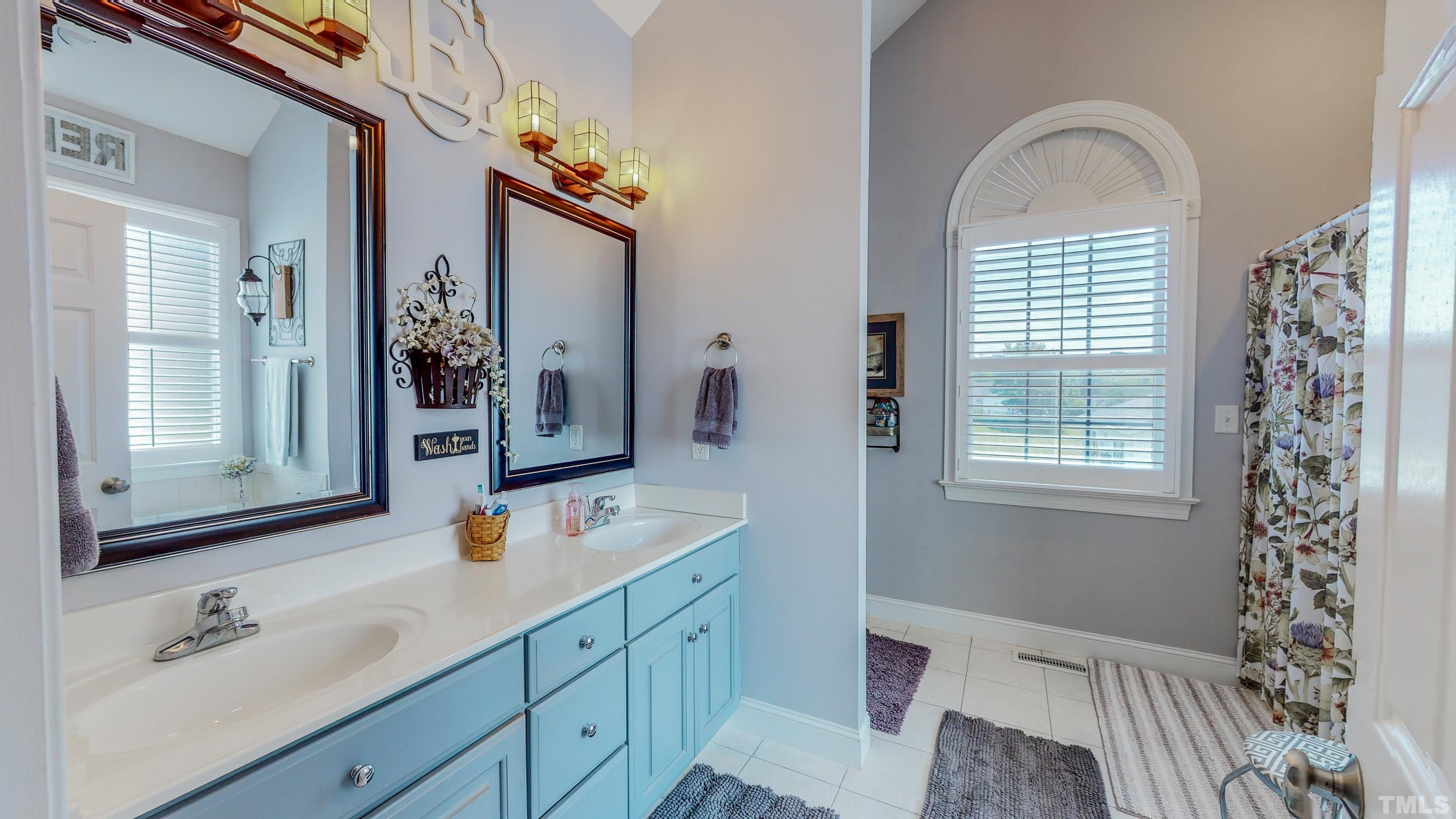 103 Derwin Drive Timberlake, NC 27583 - Photo 21 of 57 a bathroom with a sink a mirror and next to a window