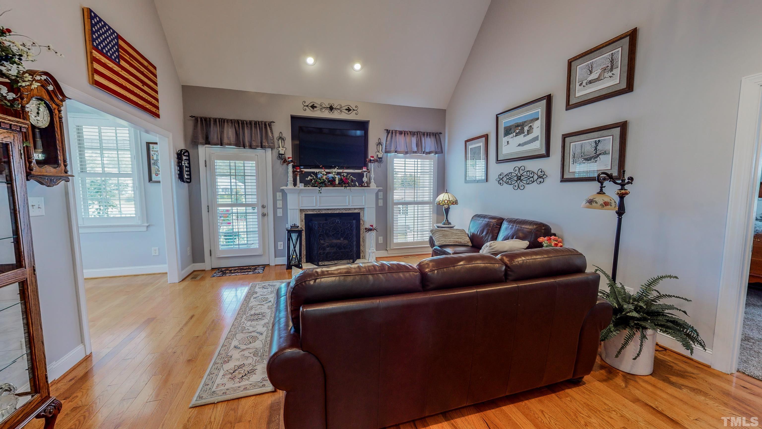 103 Derwin Drive Timberlake, NC 27583 - Photo 28 of 57 a living room with furniture a flat screen tv and a fireplace