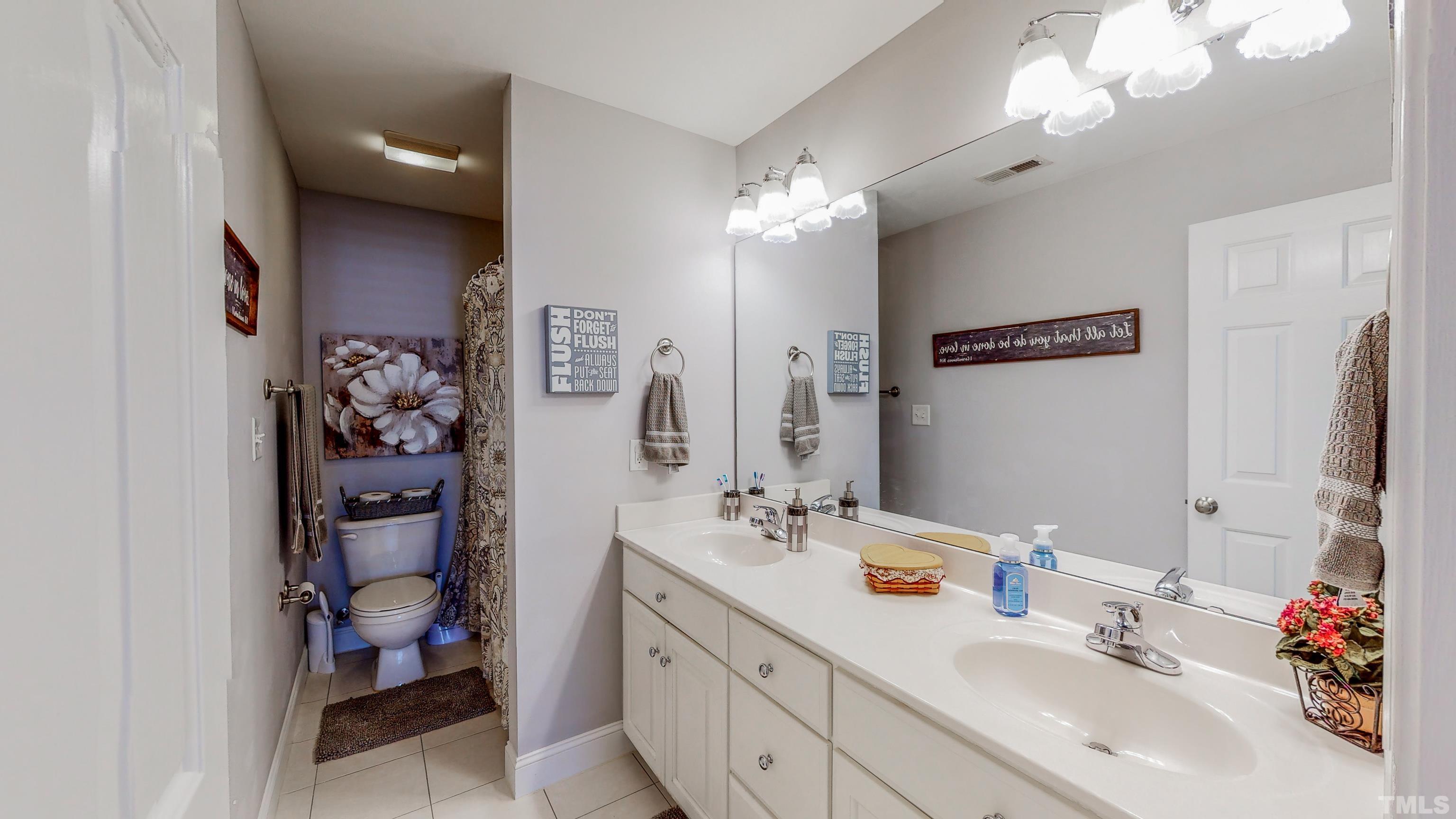 103 Derwin Drive Timberlake, NC 27583 - Photo 37 of 57 a bathroom with a sink double vanity and a mirror