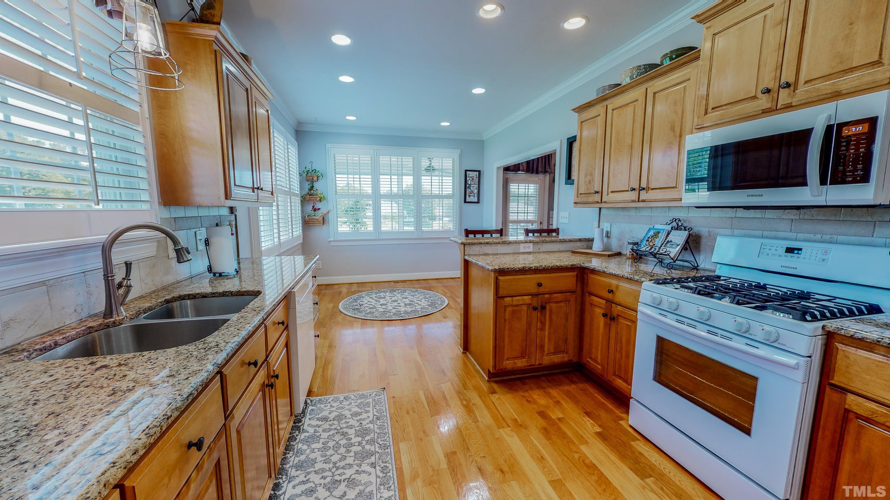 103 Derwin Drive Timberlake, NC 27583 - Photo 5 of 57 a kitchen with stainless steel appliances granite countertop a sink stove and cabinets