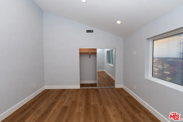 a view of empty room with wooden floor