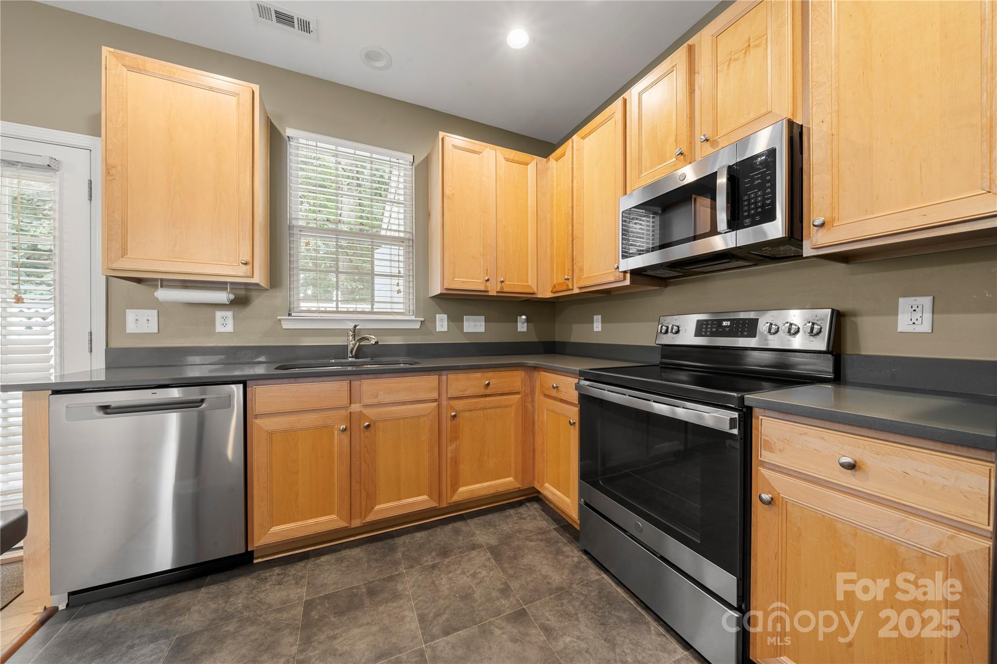 943 Copperstone Lane Fort Mill, SC 29708 - Photo 5 of 37 a kitchen with stainless steel appliances granite countertop a stove a sink and a microwave