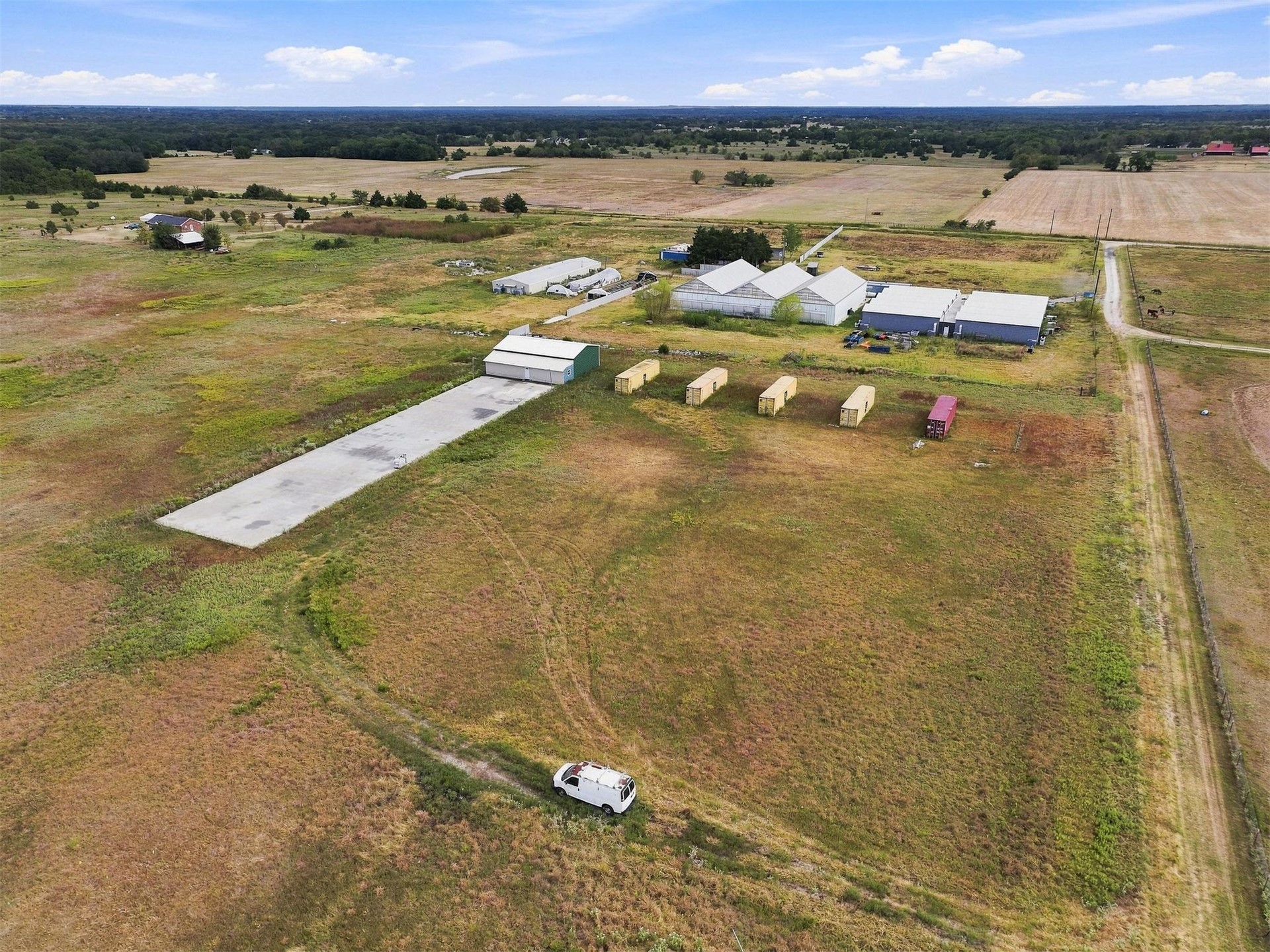180 Tower Road Bokchito, OK 74726 - Photo 24 of 49 Expansive property featuring multiple outbuildings, greenhouses, a concrete pad, and vast open land