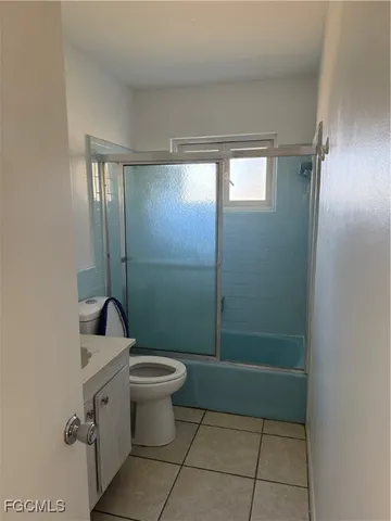 a bathroom with a granite countertop toilet a sink and shower
