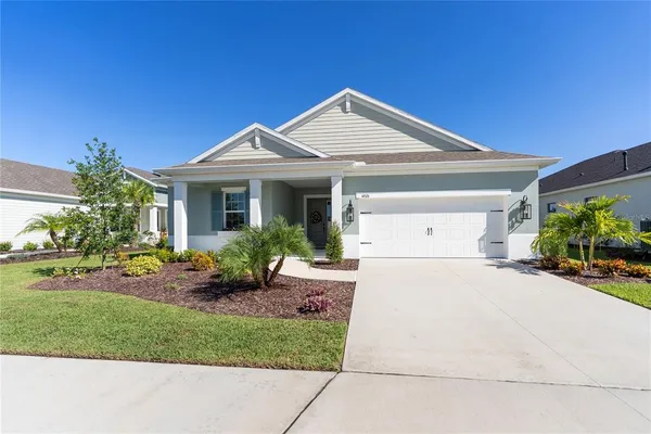 a front view of a house with a yard and potted plants