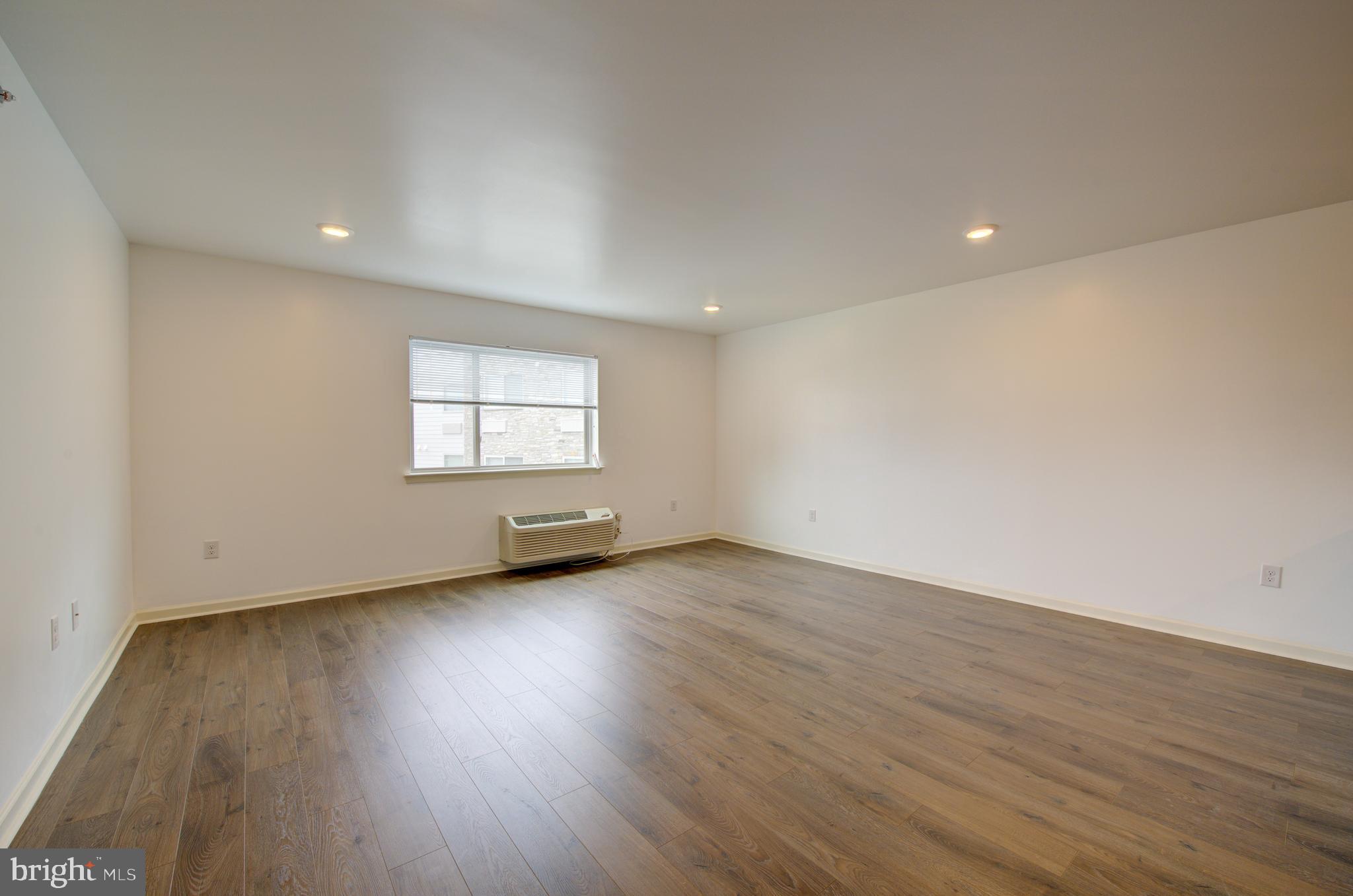 6649 Ridge Avenue, Unit B201 Philadelphia, PA 19128 - Photo 7 of 12 a view of a big room with wooden floor and windows