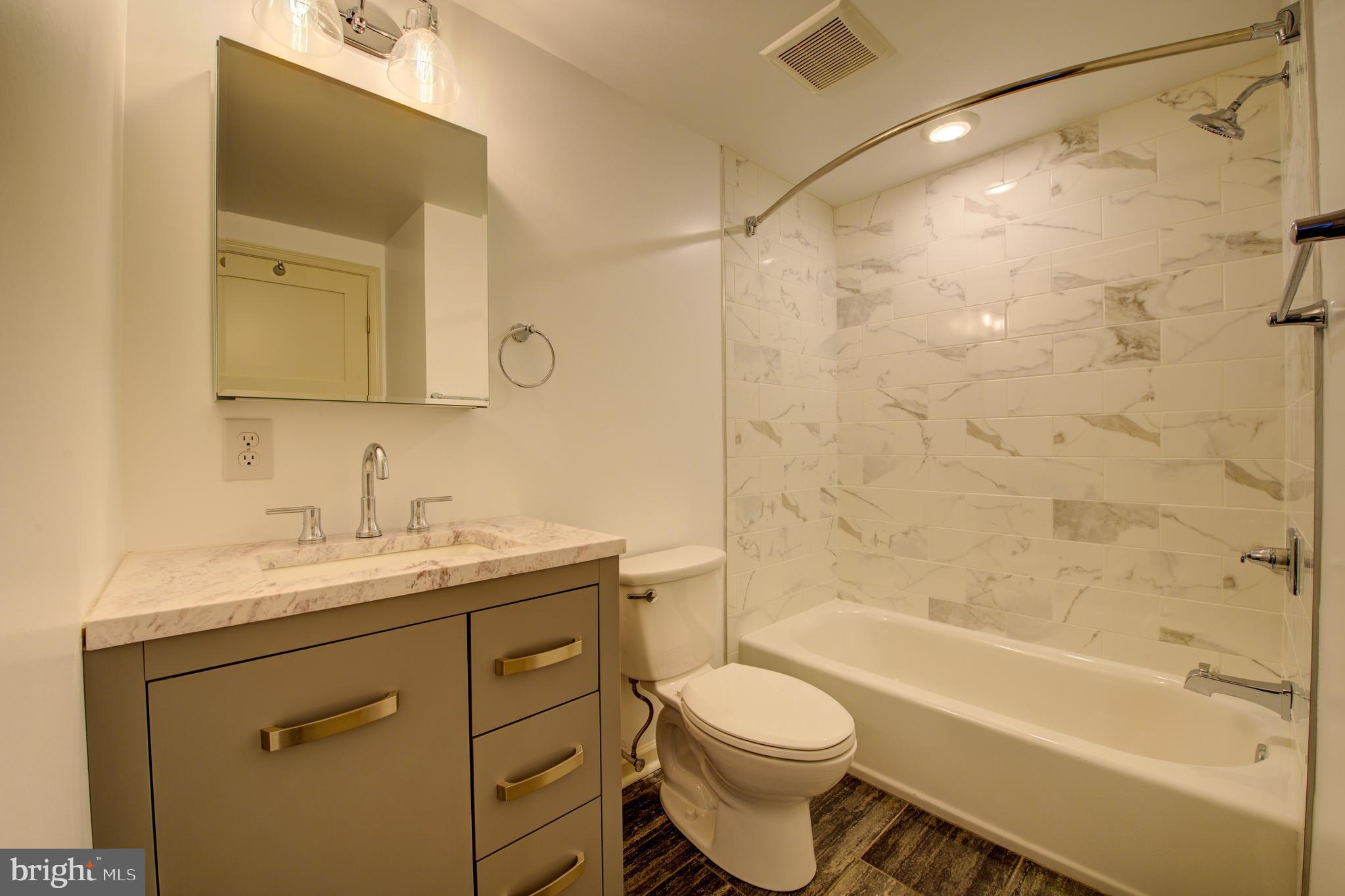 6649 Ridge Avenue, Unit B201 Philadelphia, PA 19128 - Photo 9 of 12 a bathroom with a granite countertop sink toilet and shower