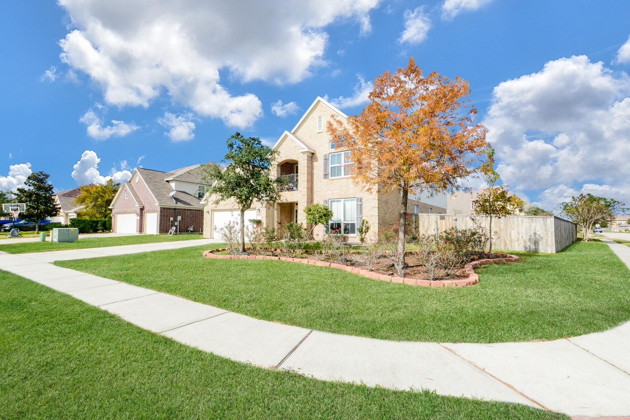 9947 Valance Way Conroe, TX 77385 - Photo 2 of 48 a view of a white house with a big yard and large trees