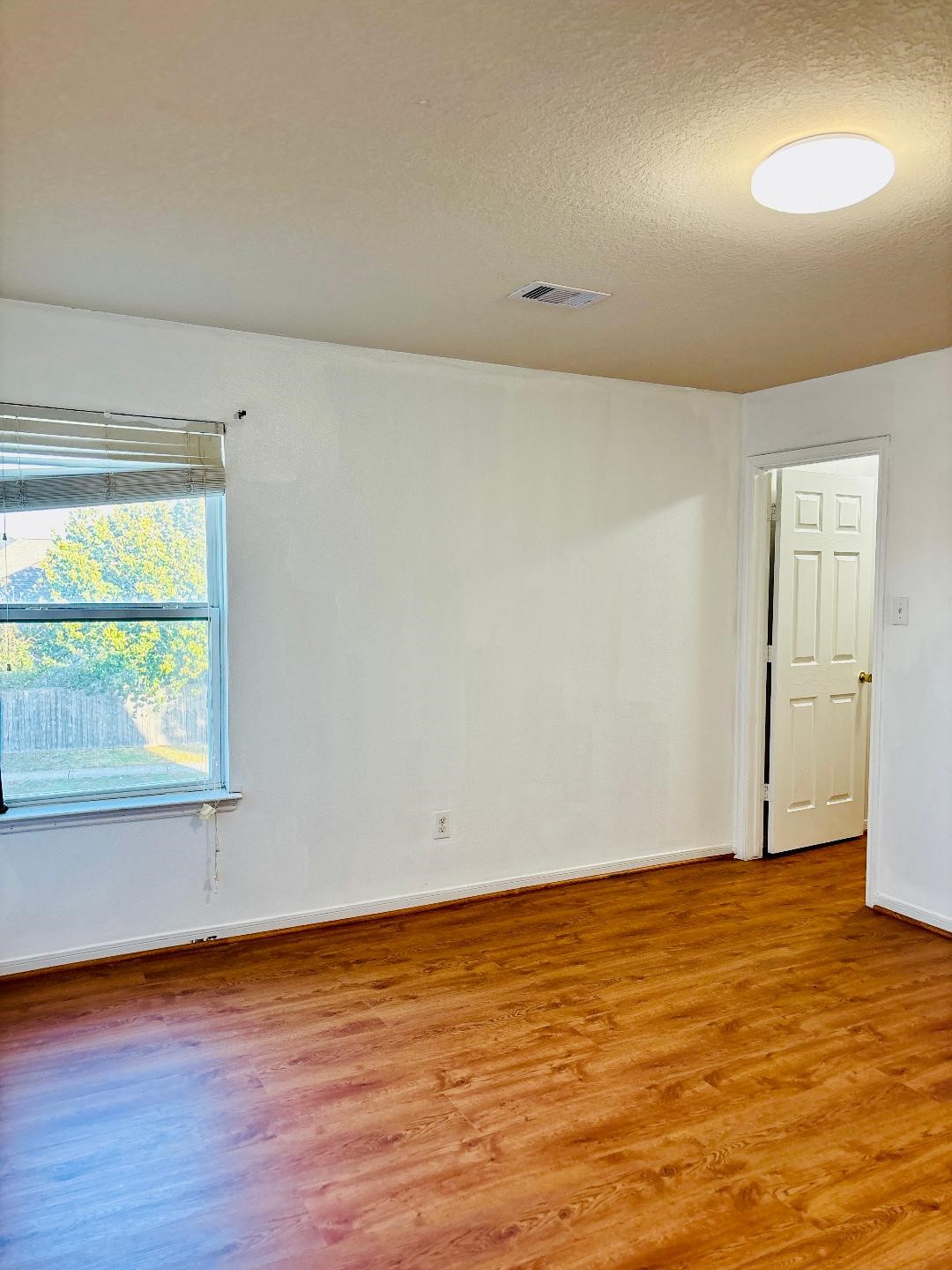 9947 Valance Way Conroe, TX 77385 - Photo 28 of 48 an empty room with wooden floor and windows
