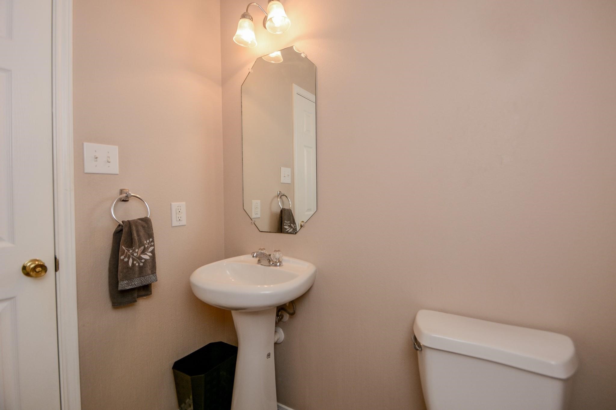 9947 Valance Way Conroe, TX 77385 - Photo 34 of 48 a bathroom with a toilet sink and mirror