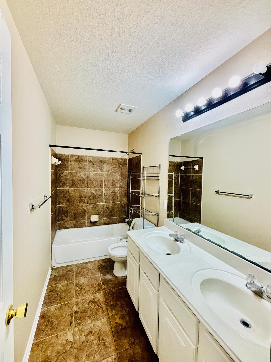9947 Valance Way Conroe, TX 77385 - Photo 35 of 48 a bathroom with a double vanity sink a large mirror and bathtub