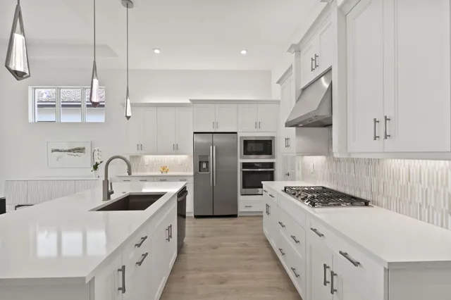 a kitchen with stainless steel appliances a sink stove and refrigerator