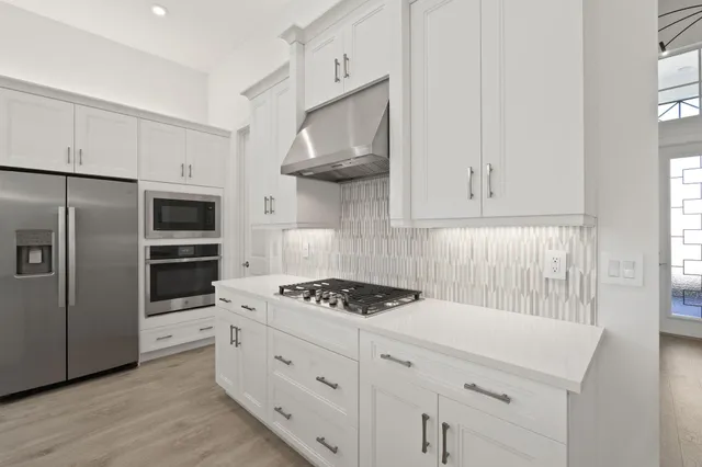 a kitchen with stainless steel appliances a cabinets and a stove top oven