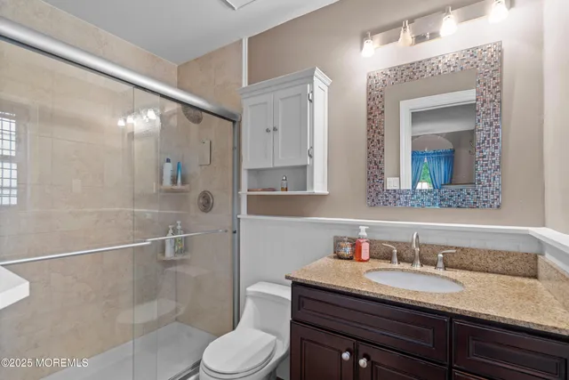 a bathroom with a sink a toilet and shower