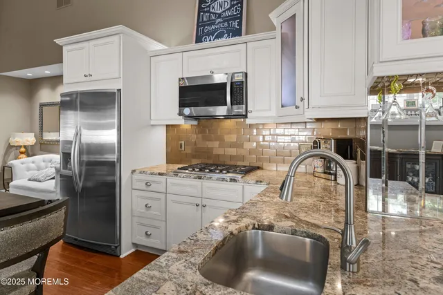 a kitchen with stainless steel appliances granite countertop a stove and a refrigerator