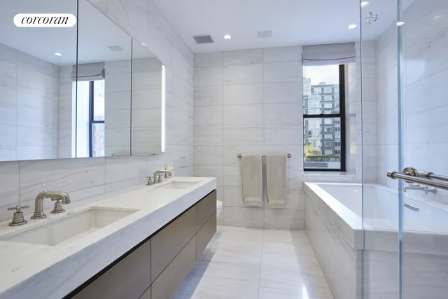 a bathroom with a tub sink and mirror