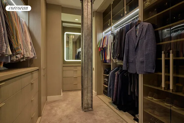 a view of walk in closet with clothes and shoes