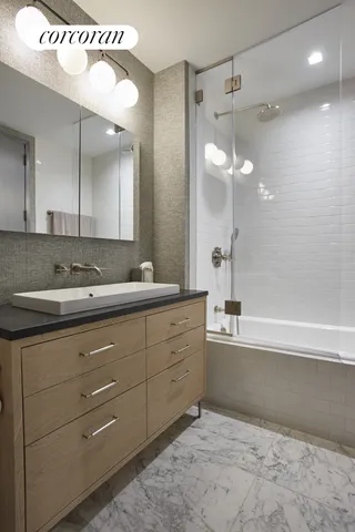 a bathroom with a sink a mirror and a shower