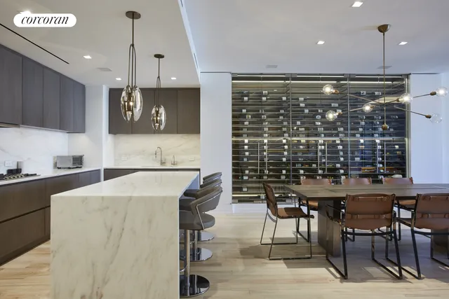 a kitchen with stainless steel appliances kitchen island granite countertop a table chairs and a refrigerator