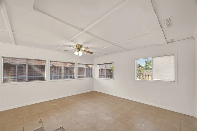 an empty room with a window and a ceiling fan