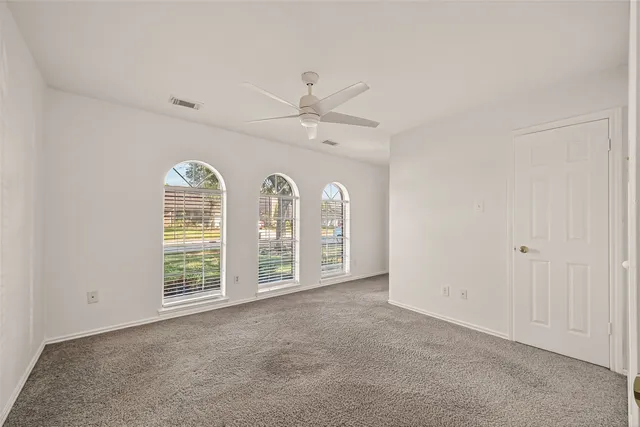 a view of a room with a ceiling fan and a window