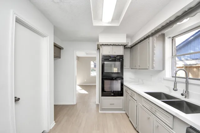 a kitchen with granite countertop a sink and refrigerator