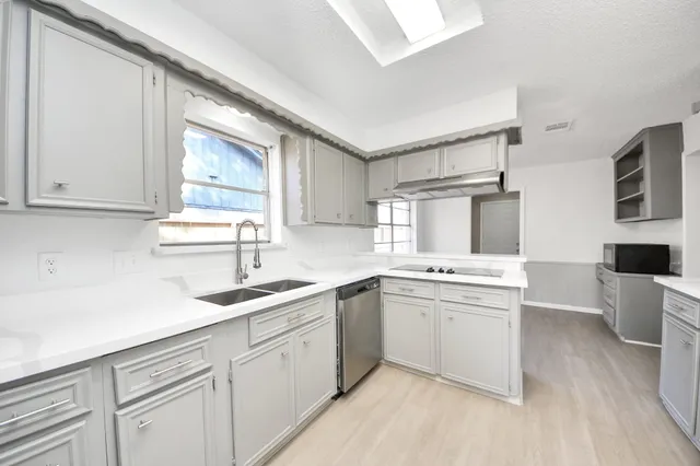 a kitchen with sink cabinets and wooden floor