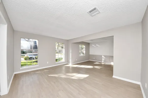 an empty room with windows and mirror