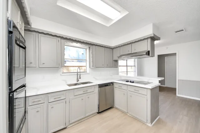 a kitchen with a sink stove and cabinets