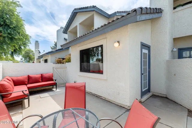 a backyard of a house with table and chairs
