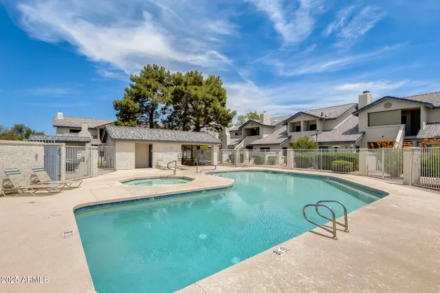 a swimming pool with outdoor seating and a kitchen