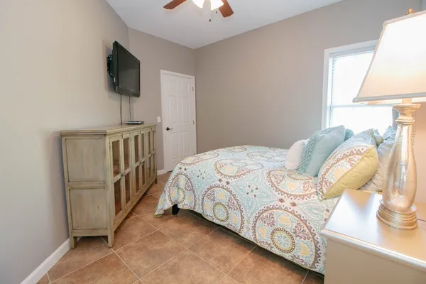 a bedroom with a bed a flat screen tv and a window
