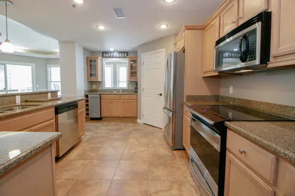 a kitchen with stainless steel appliances granite countertop a refrigerator and a stove top oven