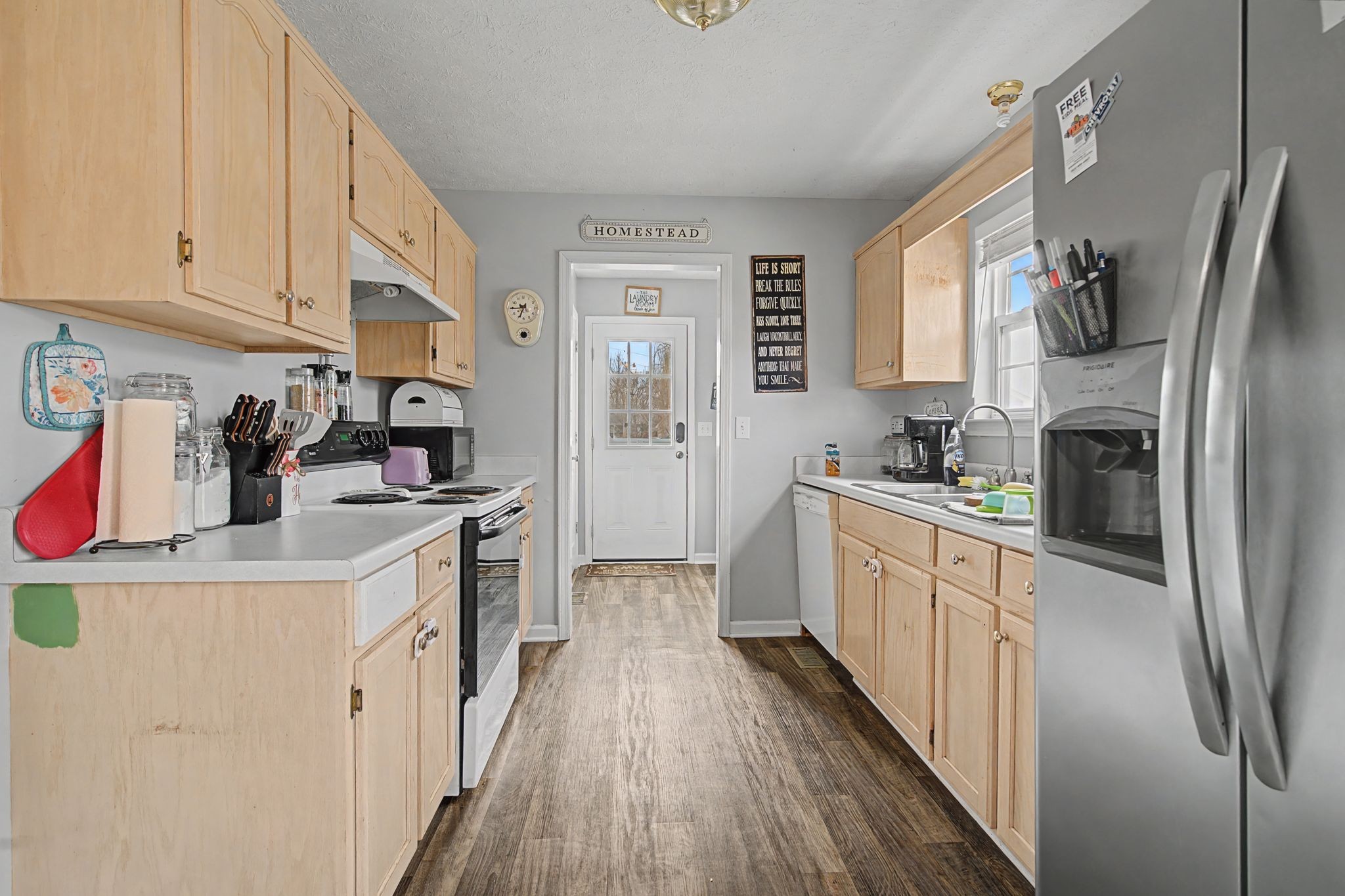 105 Cora Street Portland, TN 37148 - Photo 9 of 31 a kitchen with stainless steel appliances a refrigerator a sink a stove and white cabinets