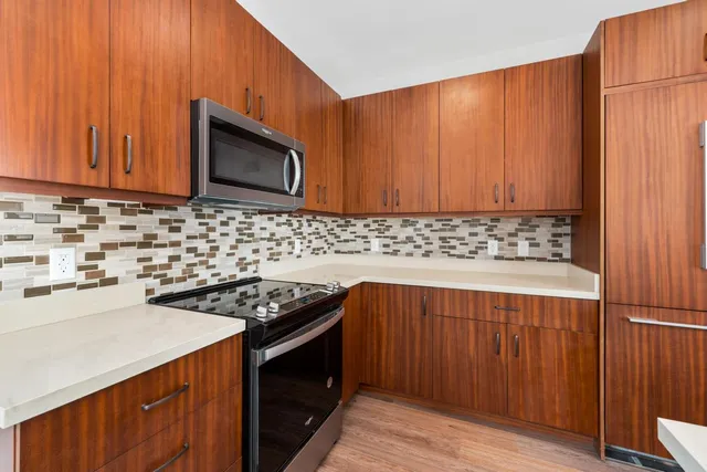 a kitchen with stainless steel appliances a stove a sink and a microwave