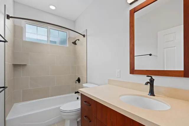a bathroom with a granite countertop sink a toilet and shower