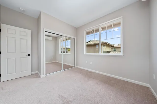an empty room with windows and closet