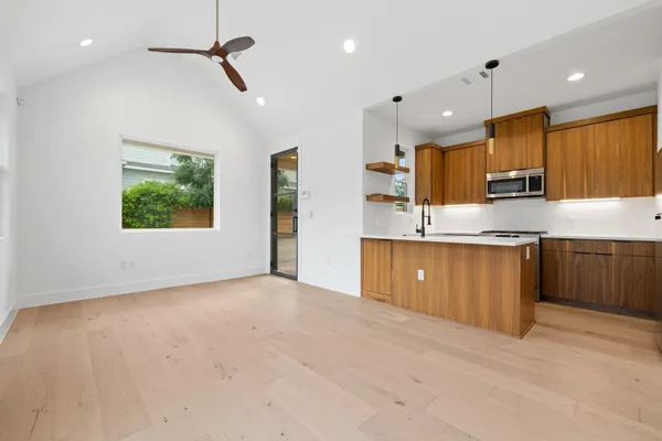 a large kitchen with kitchen island a sink dishwasher a stove and a refrigerator with wooden floor