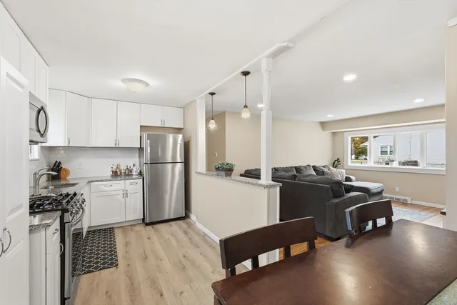 a kitchen with cabinets stainless steel appliances and wooden floor
