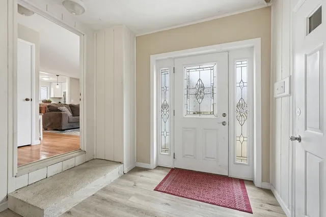 a view of an empty room with wooden floor and a cabinet