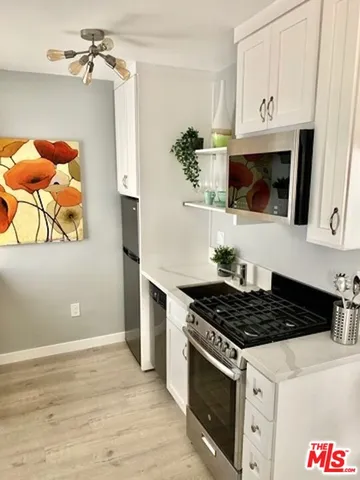 a kitchen with stainless steel appliances a stove and a microwave