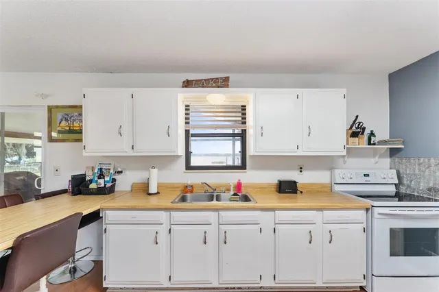 a kitchen with granite countertop white cabinets and white appliances