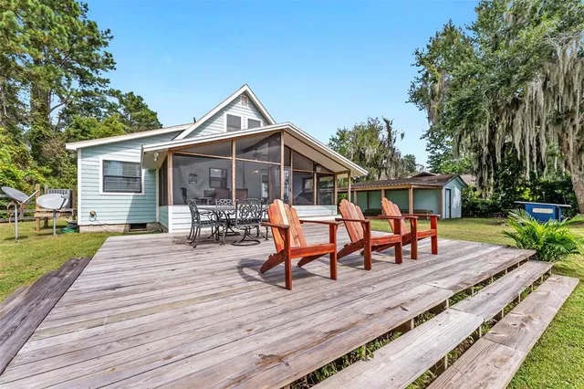 a view of a roof deck with table and chairs a barbeque with wooden floor and fence