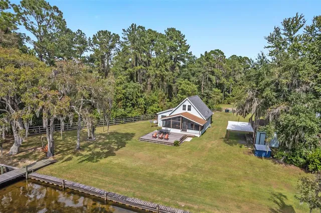 an aerial view of a house with a yard and lake view