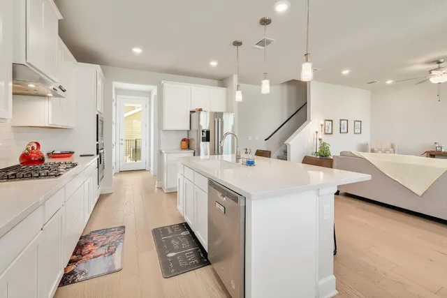 a kitchen with kitchen island a sink appliances and a counter top space