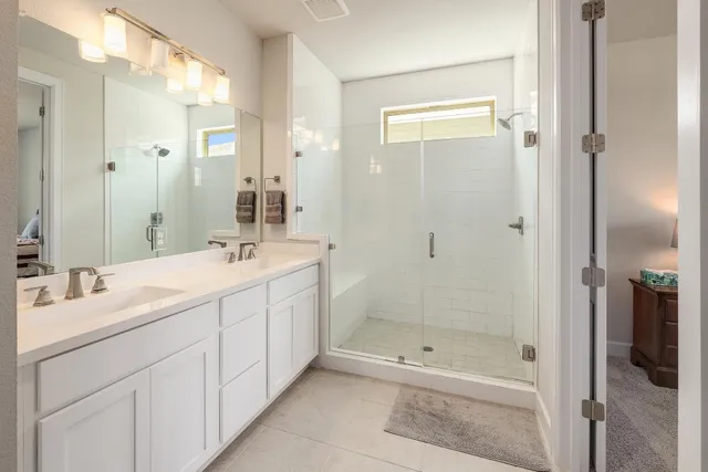 a bathroom with a double vanity sink shower and a mirror