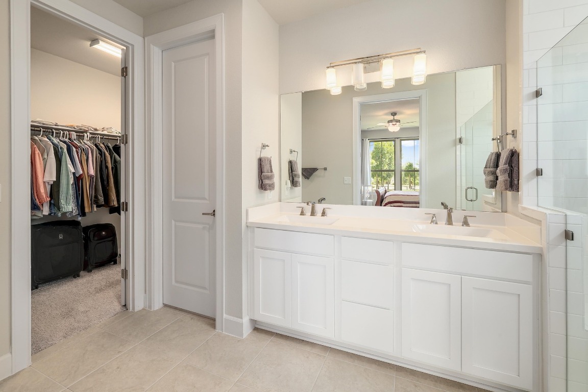 8312 Corrigan Pass Austin, TX 78744 - Photo 17 of 27 a bathroom with a double vanity sink a mirror and a shower