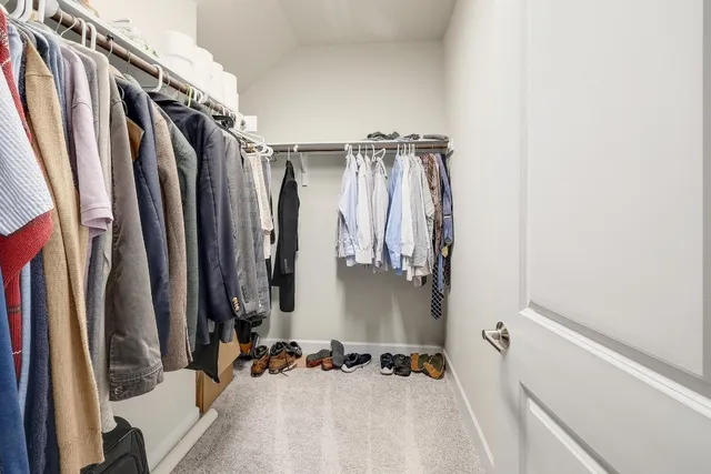 a view of walk in closet with clothes and shoes