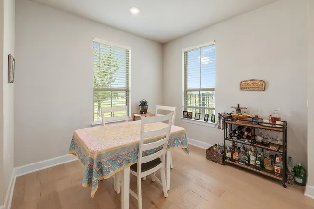 a bedroom with a bed a table and a dresser next to a window