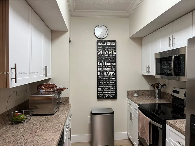 a kitchen with stainless steel appliances granite countertop a sink refrigerator and microwave